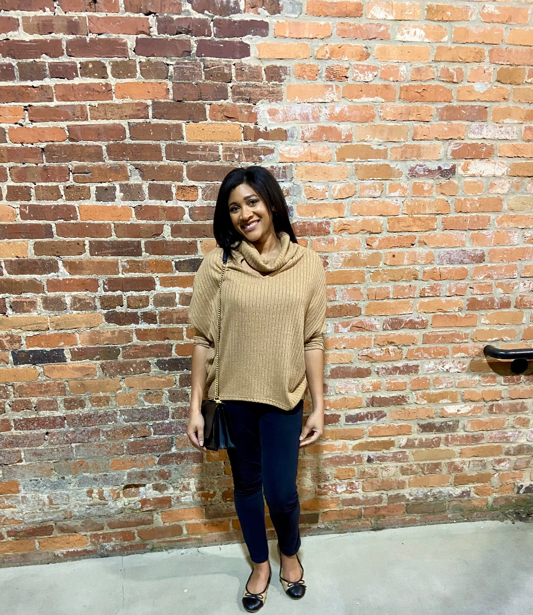 Woman wearing camel brown pleated rolled neck sweater black jeggings and ballet flats